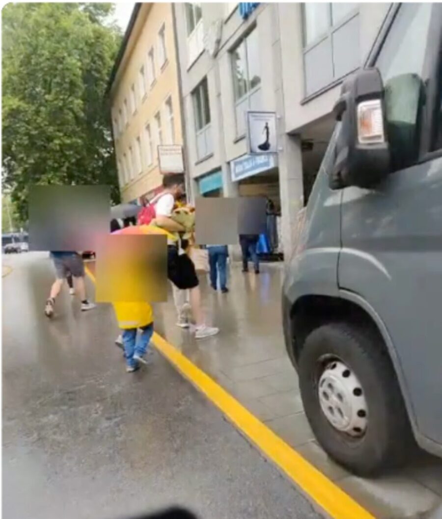 Rider's view: a van stopped at the kerb with pedestrians moving across the lane beside it.